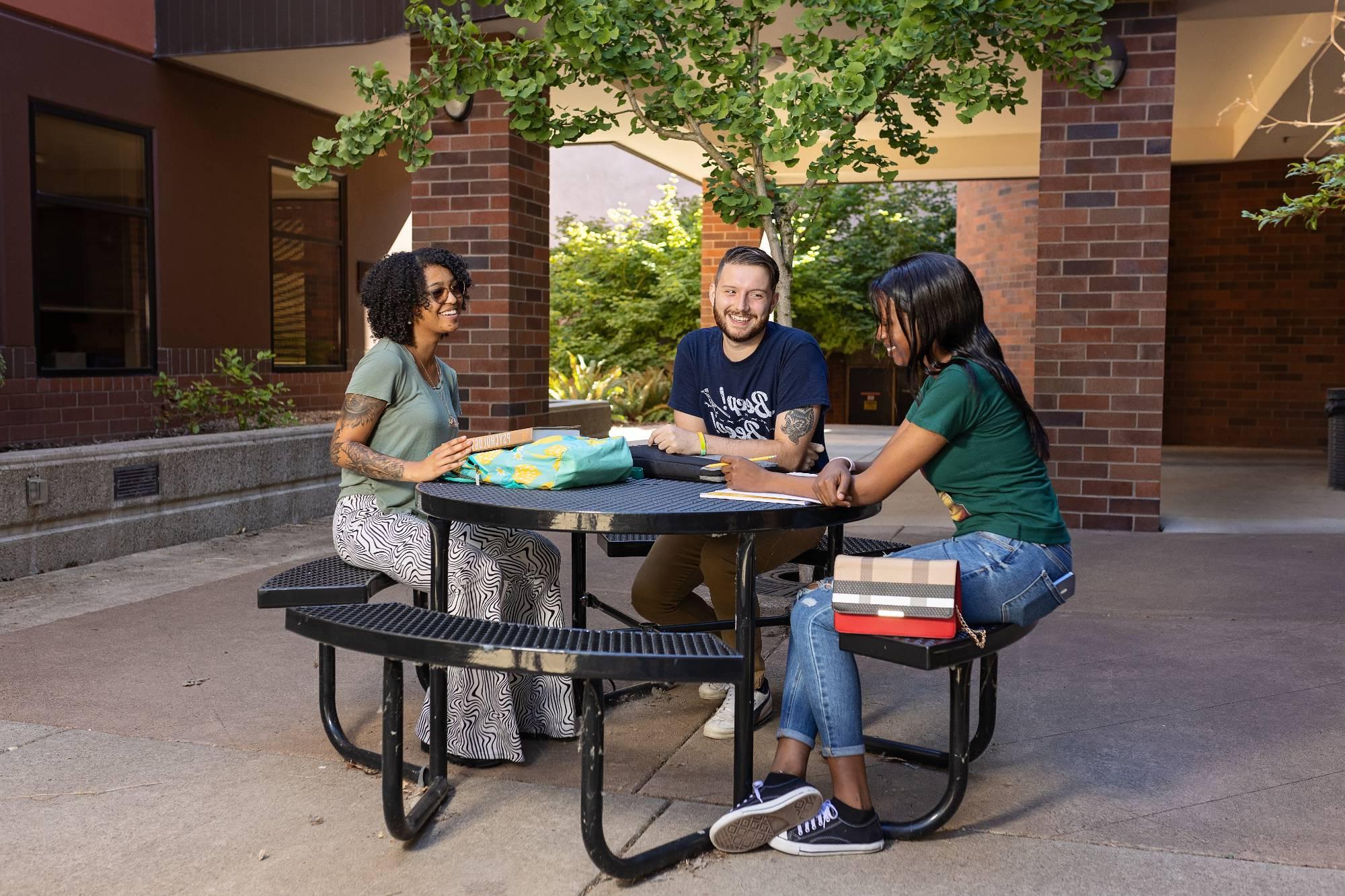 photo of students sitting at an outdoor table